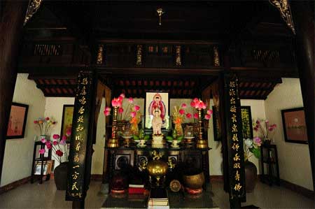 Floral offerings: A family altar decorated with paper lotus flowers. Thanh tien village